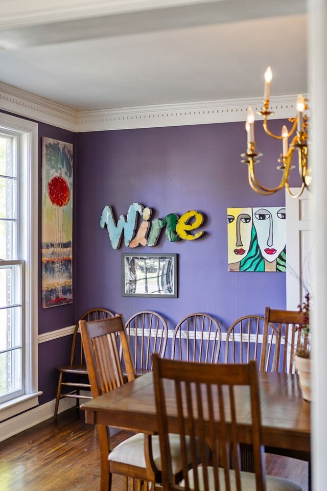 dining room featuring baseboards, wood finished floors, and a notable chandelier