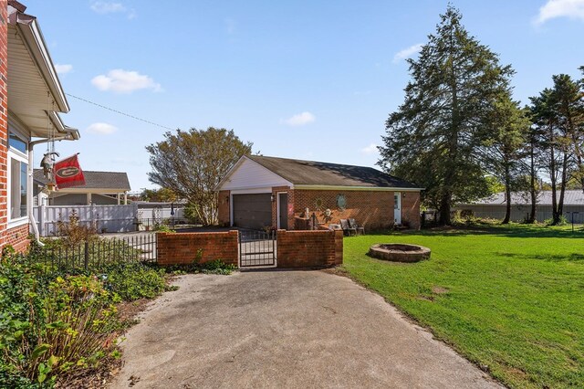 view of front facade with a fire pit, an outbuilding, fence, a front lawn, and brick siding