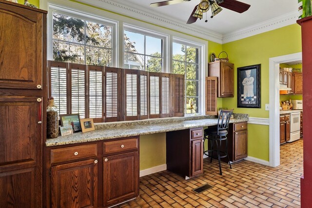 kitchen with electric range, visible vents, brick floor, crown molding, and built in desk