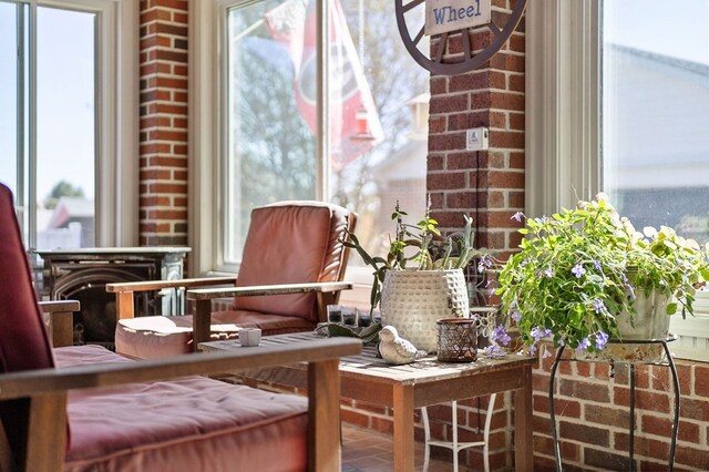 interior space featuring brick wall and a healthy amount of sunlight