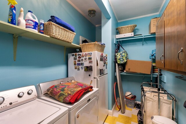 laundry area featuring ornamental molding, cabinet space, washer and clothes dryer, and light floors