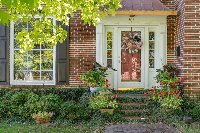 doorway to property featuring brick siding