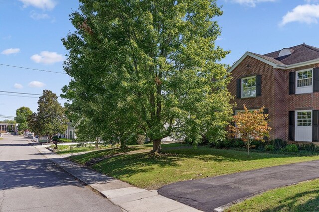 view of side of home with a yard and brick siding