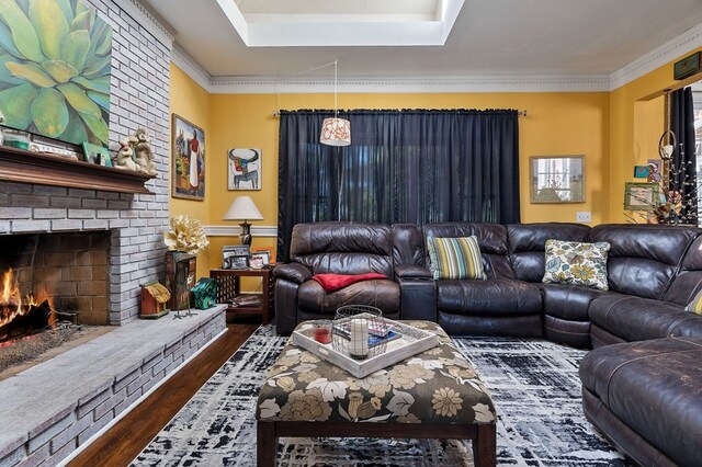 living room featuring dark wood-style floors, crown molding, and a fireplace