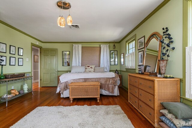 bedroom featuring crown molding, visible vents, dark wood finished floors, and baseboards