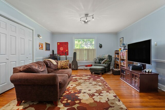 living area featuring light wood-type flooring and crown molding