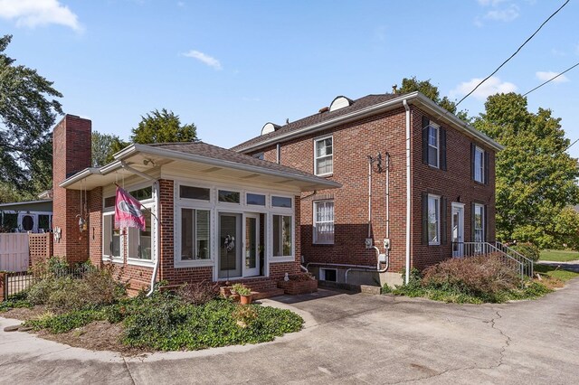 exterior space with brick siding and a chimney