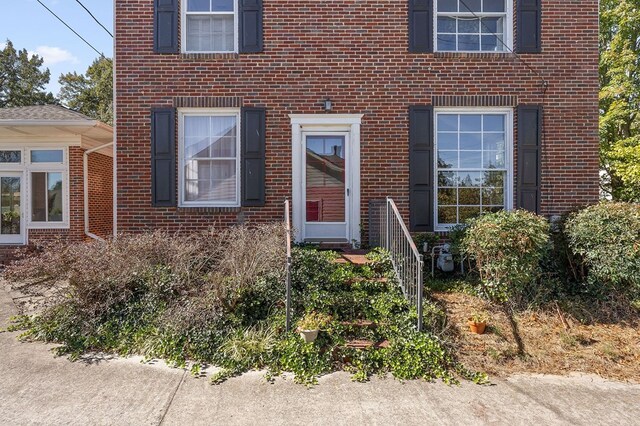 entrance to property featuring brick siding