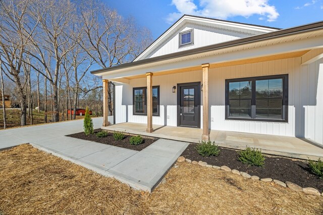 view of exterior entry featuring covered porch