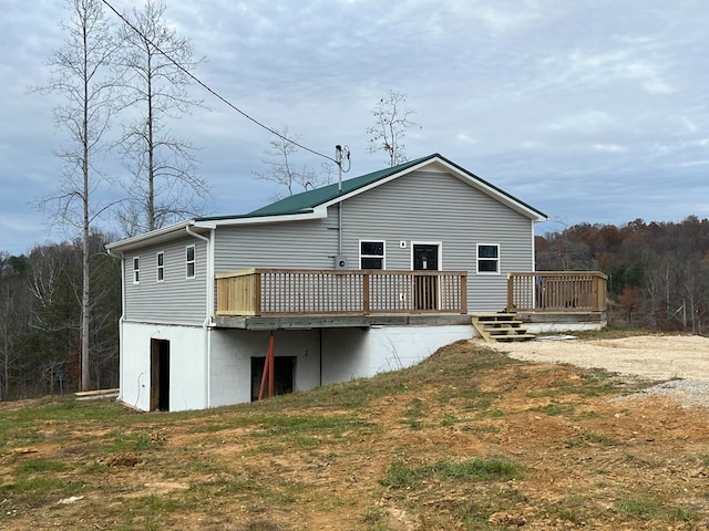 back of property with a lawn and a deck