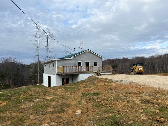 exterior space with a deck and dirt driveway