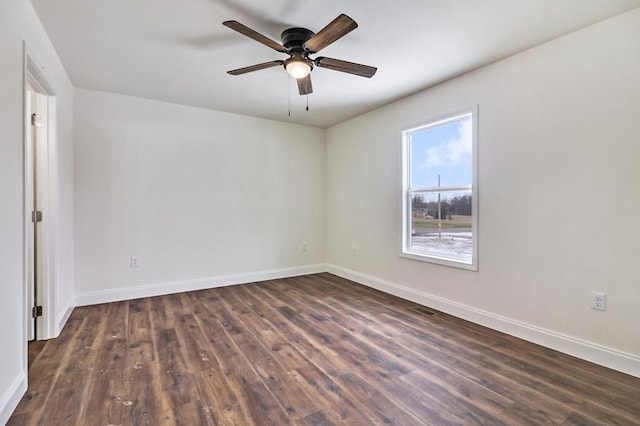 empty room with a ceiling fan, dark wood-style flooring, and baseboards