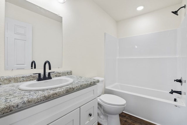 full bathroom featuring toilet, bathing tub / shower combination, wood finished floors, and vanity