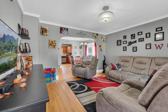 living area with baseboards, crown molding, arched walkways, and wood finished floors