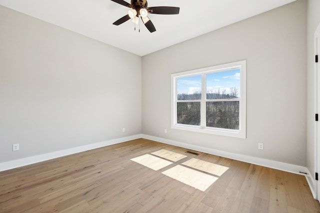 spare room with visible vents, baseboards, a ceiling fan, and light wood finished floors