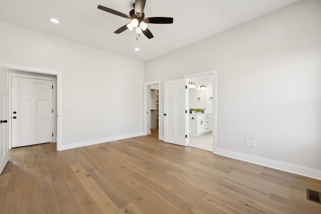 unfurnished bedroom with recessed lighting, baseboards, light wood-style floors, and ensuite bathroom