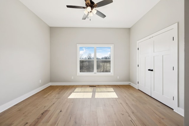 unfurnished bedroom featuring a ceiling fan, light wood-type flooring, and baseboards