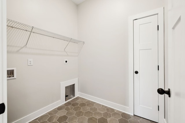 laundry room with baseboards, dark tile patterned floors, laundry area, hookup for a washing machine, and hookup for an electric dryer