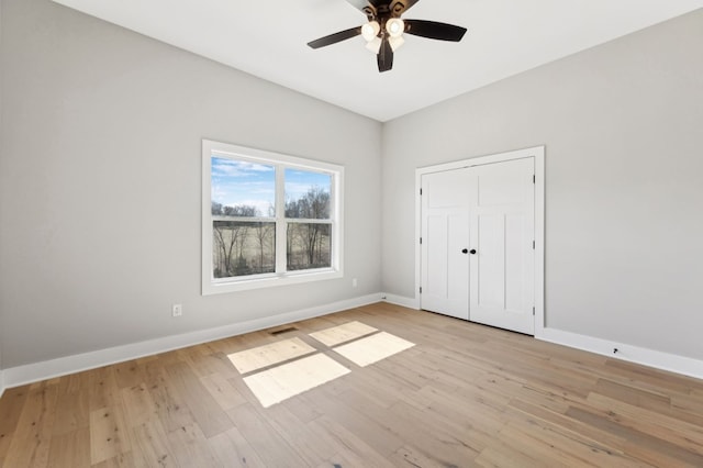 unfurnished bedroom featuring visible vents, baseboards, light wood-style floors, and a ceiling fan