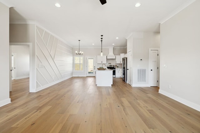 unfurnished living room with light wood-style flooring, recessed lighting, visible vents, and ornamental molding