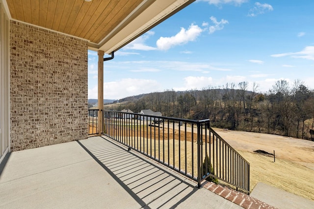 balcony featuring a wooded view