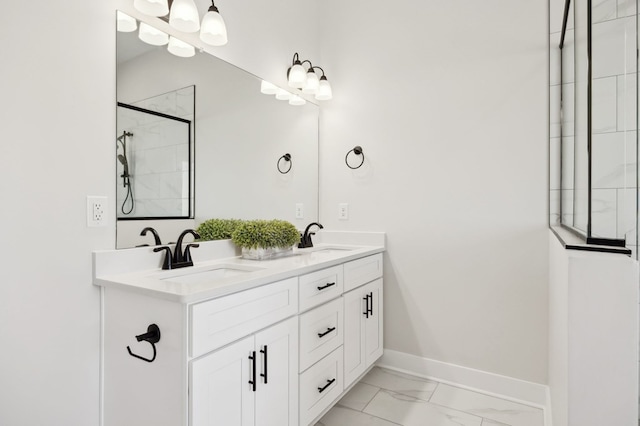 bathroom with double vanity, baseboards, marble finish floor, and a sink