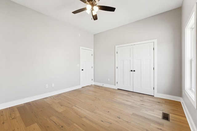 unfurnished bedroom with visible vents, a ceiling fan, a closet, light wood-style floors, and baseboards