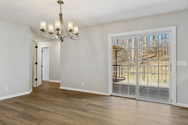 unfurnished dining area with plenty of natural light, baseboards, and wood finished floors