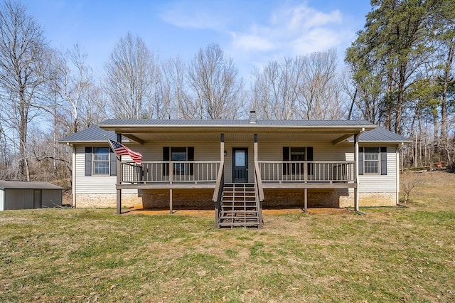 single story home with a porch, metal roof, a front lawn, and stairs