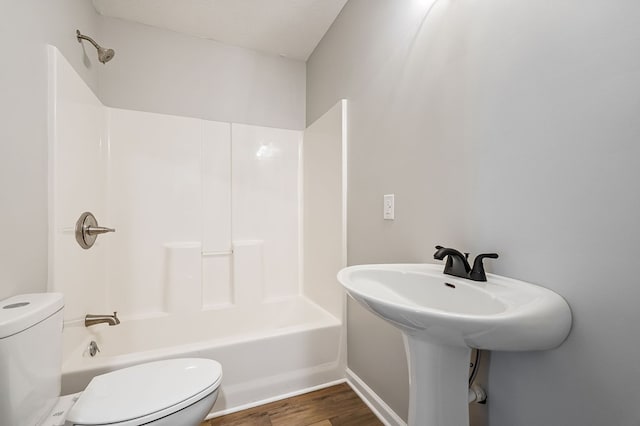 full bath featuring bathtub / shower combination, wood finished floors, and toilet