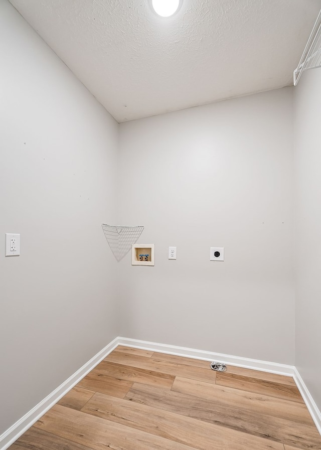 laundry area with hookup for an electric dryer, laundry area, washer hookup, baseboards, and light wood finished floors