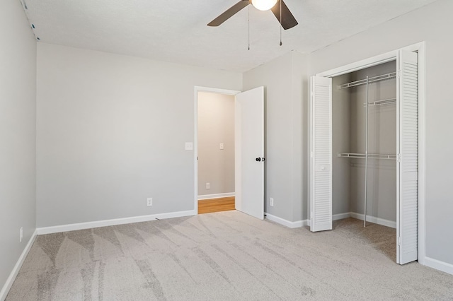 unfurnished bedroom featuring baseboards, ceiling fan, carpet, a textured ceiling, and a closet