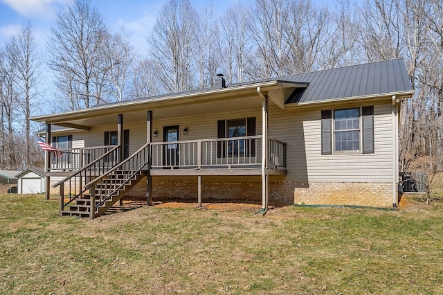 single story home with brick siding, a chimney, a porch, a front yard, and metal roof