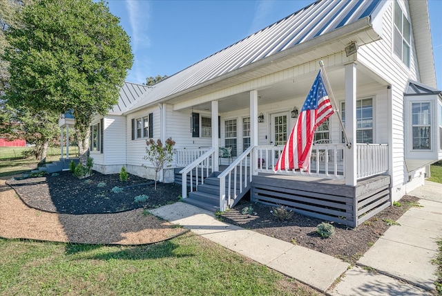 view of front of property with metal roof, a porch, and a standing seam roof