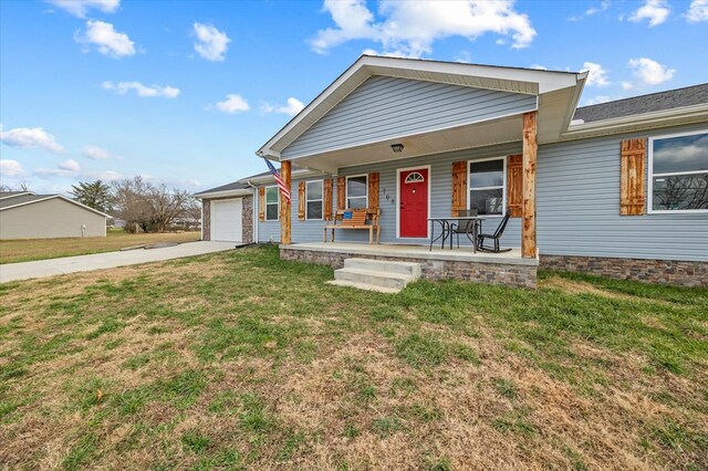 ranch-style house with an attached garage, a porch, concrete driveway, and a front yard