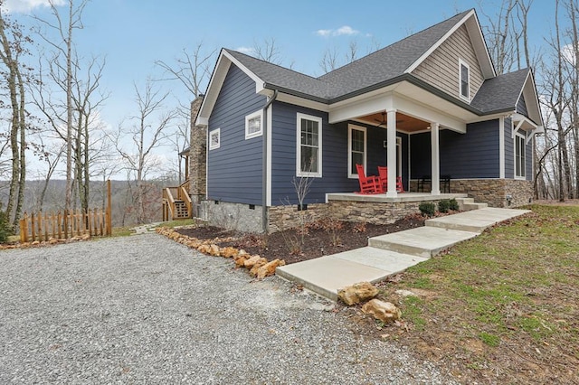 view of front of property featuring a porch, roof with shingles, and fence