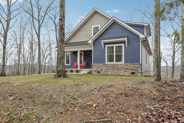 view of front of home with crawl space, stone siding, and covered porch