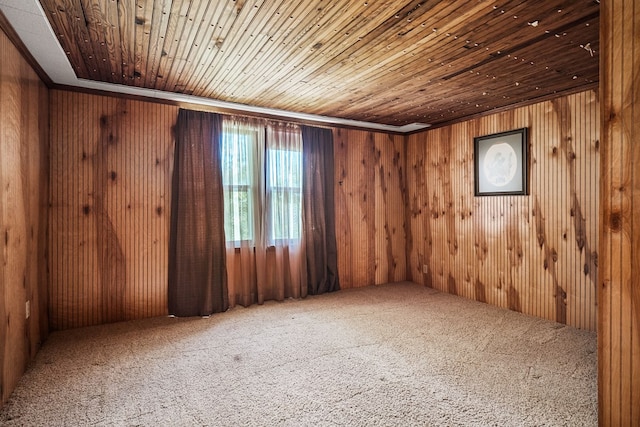 unfurnished room featuring carpet floors, wooden ceiling, and wooden walls