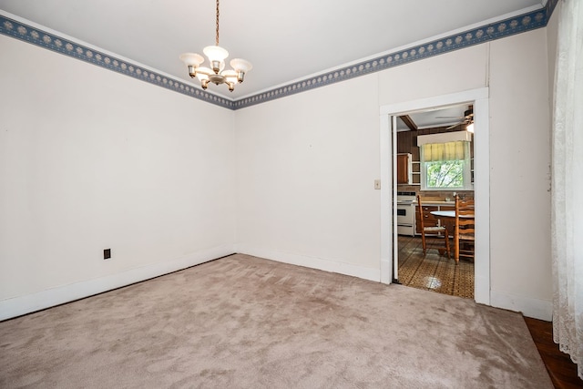 spare room with carpet flooring, baseboards, and ceiling fan with notable chandelier