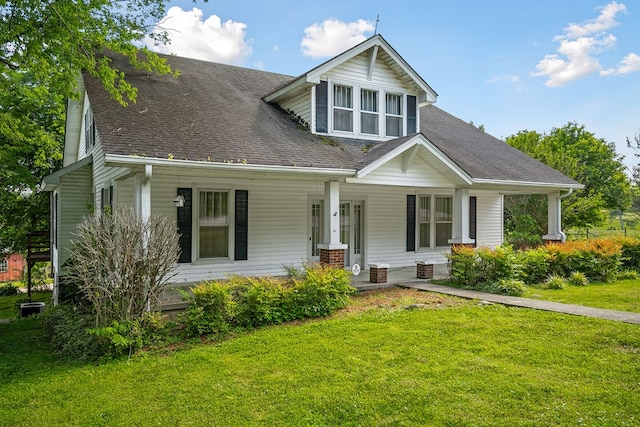 view of front of property with a front lawn, a porch, and roof with shingles