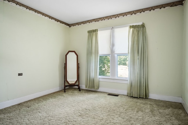 unfurnished room featuring baseboards, visible vents, and light colored carpet