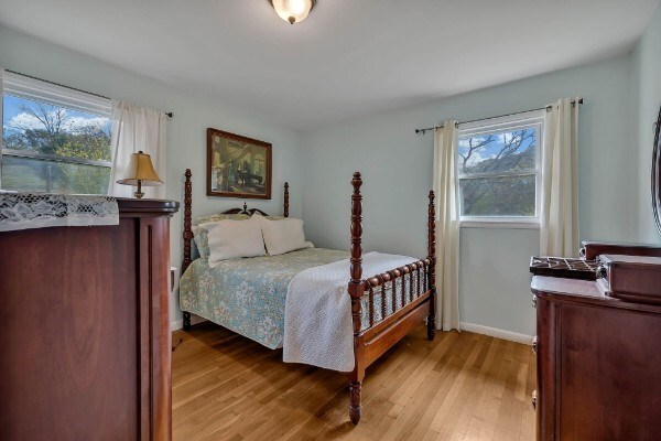 bedroom featuring multiple windows, light wood-type flooring, and baseboards