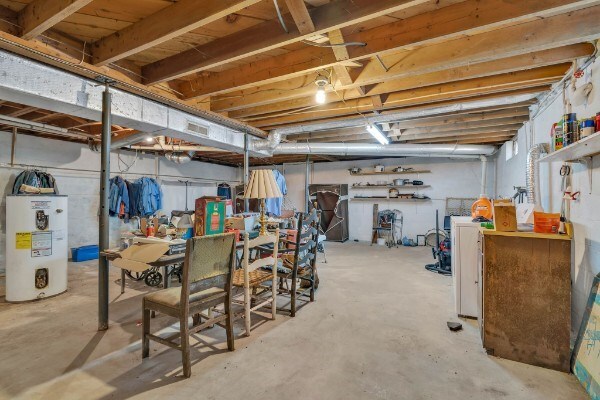 unfinished basement featuring water heater