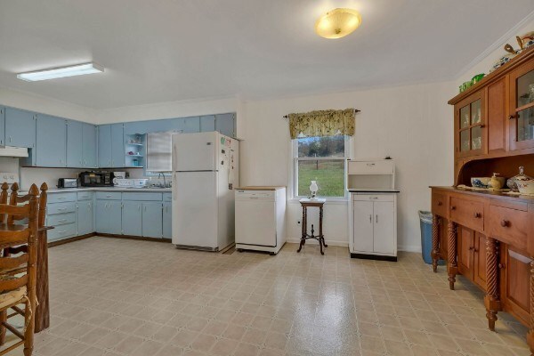 kitchen with white appliances, under cabinet range hood, brown cabinetry, and light floors