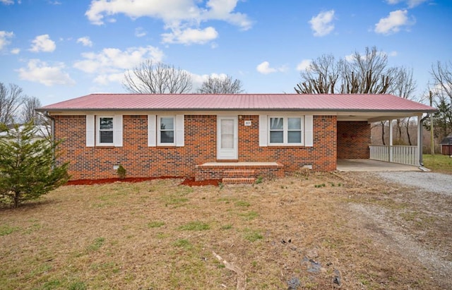 single story home featuring brick siding, metal roof, a carport, and dirt driveway