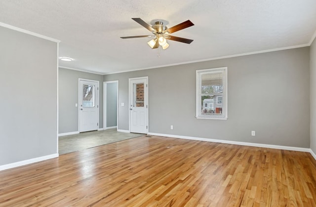 spare room featuring light wood-style flooring, a ceiling fan, baseboards, and ornamental molding