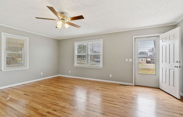 unfurnished room with baseboards, light wood-style floors, ornamental molding, and a textured ceiling