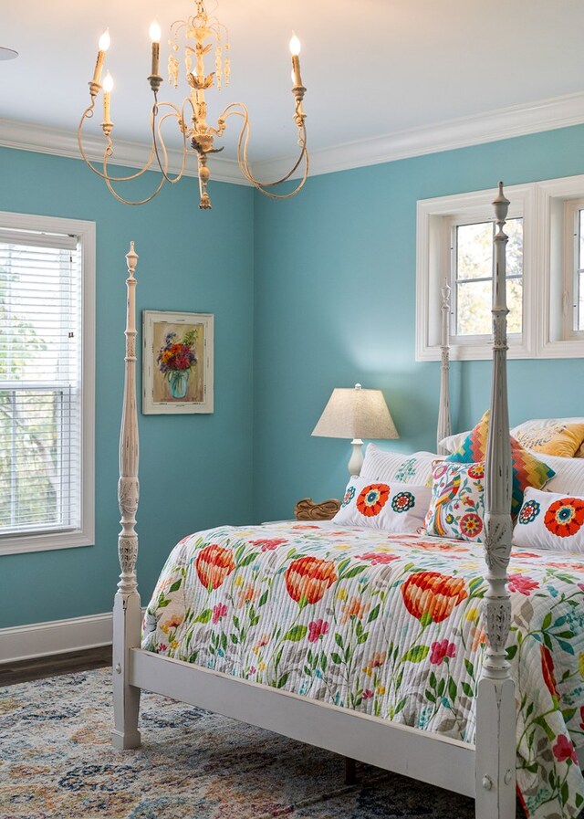 bedroom with multiple windows, crown molding, a notable chandelier, and baseboards