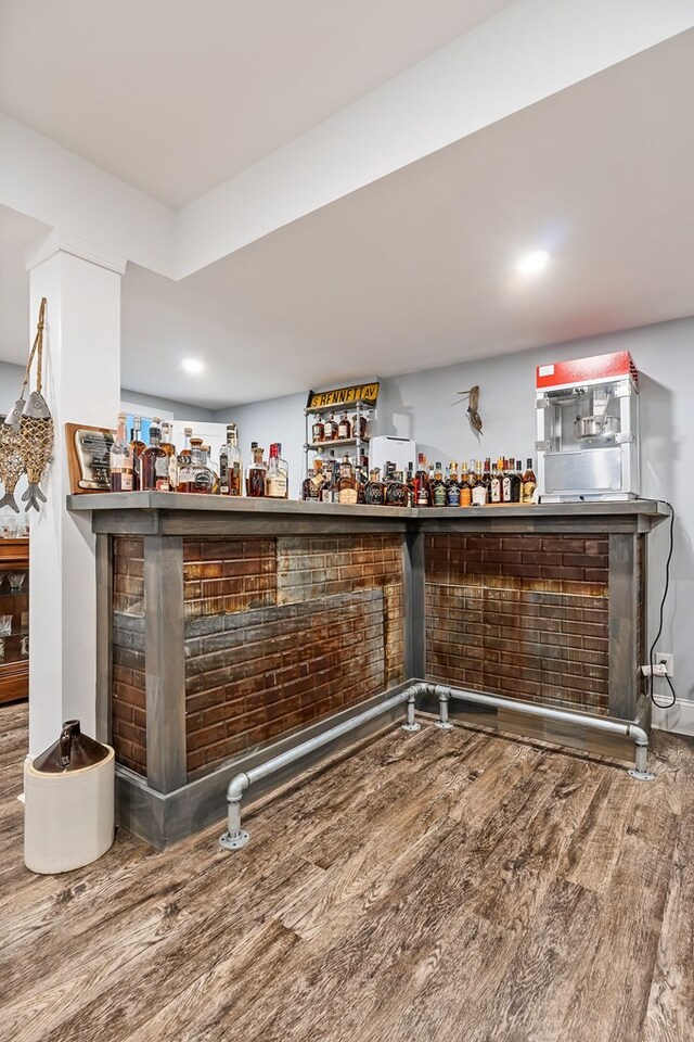 bar with a bar and wood finished floors