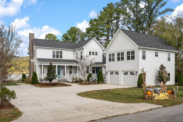 view of front of property with a porch, an attached garage, concrete driveway, board and batten siding, and a chimney